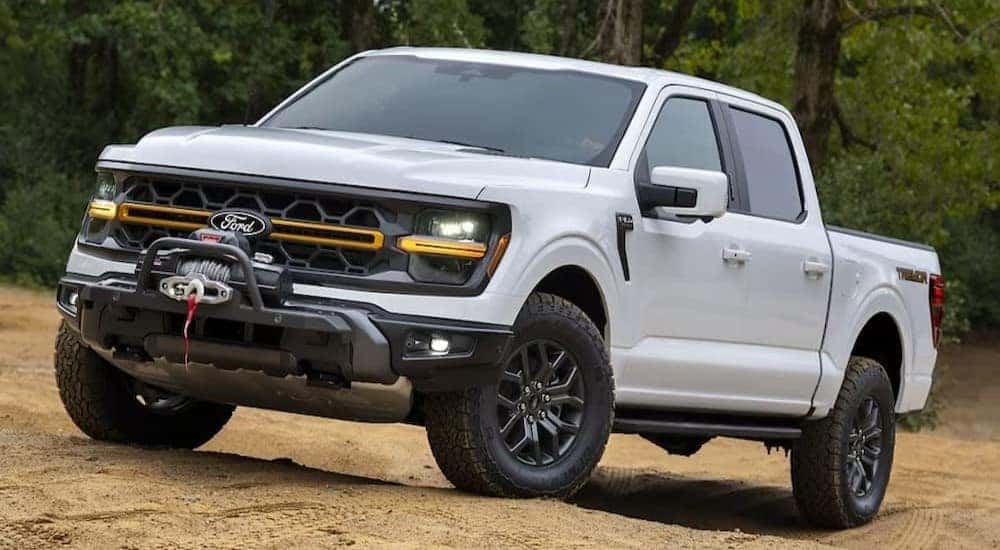 A white 2024 Ford F-150 Tremor is shown parked off-road.