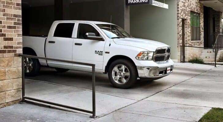 A white 2024 Ram 1500 for sale in Dallas is shown parked near a parking garage.