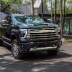 A grey 2025 Chevy Silverado 2500 HD High Country parked outside a building.