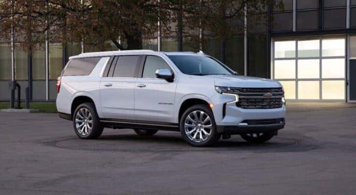 Front angle view of a white 2021 Chevy Suburban parked outside a building.