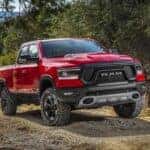 A red 2019 Ram 1500 driving off-road on a trail.