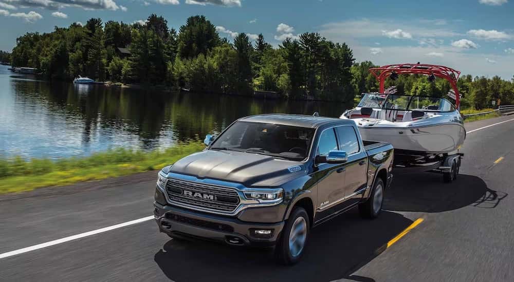 A grey 2024 Ram 1500 for sale in Cleveland towing a boat.
