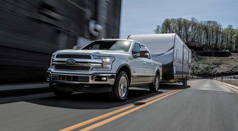 A white 2018 Ford F-150 is shown towing a trailer.