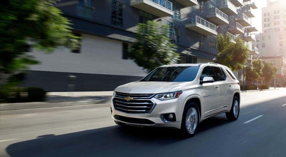 A white 2020 Chevy Traverse High Country driving down a road.