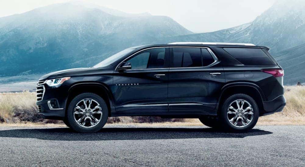 Side angle view of a black 2021 Chevy Traverse High Country parked.