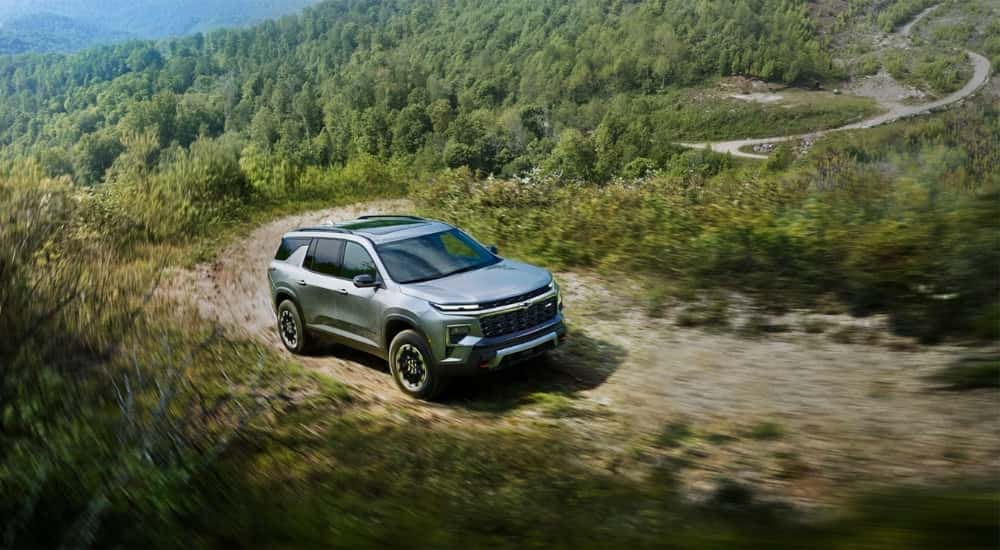 Overhead view of a silver 2024 Chevy Traverse Z71 driving on a dirt trail up a mountain.