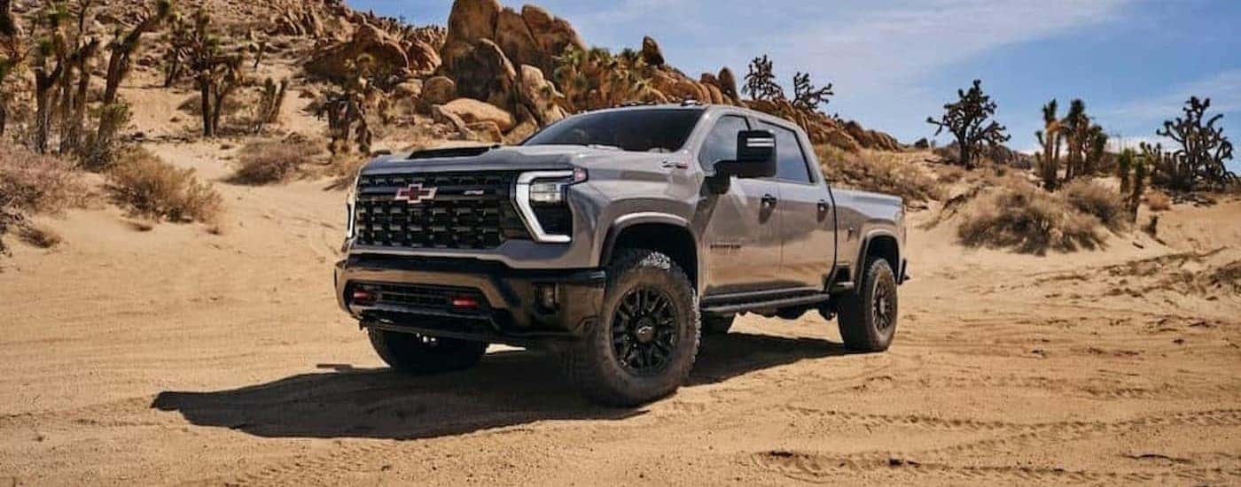 A gray 2025 Chevy Silverado 2500 HD ZR2 is shown parked off-road.