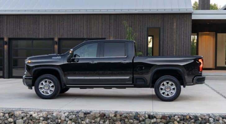 A black 2025 Chevy Silverado 2500 HD High Country is shown parked on a driveway.