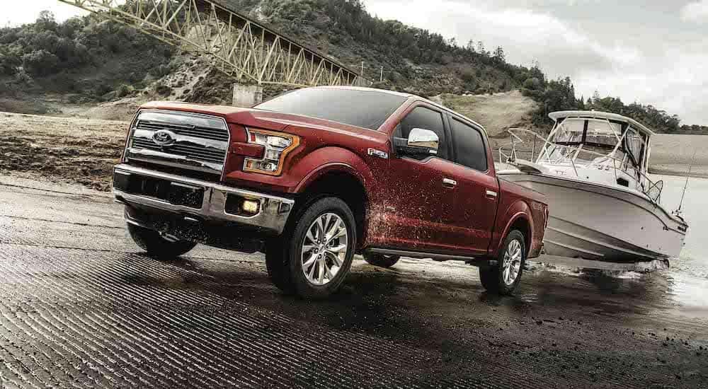 A red 2017 Ford F-150 is shown pulling a boat up a ramp.