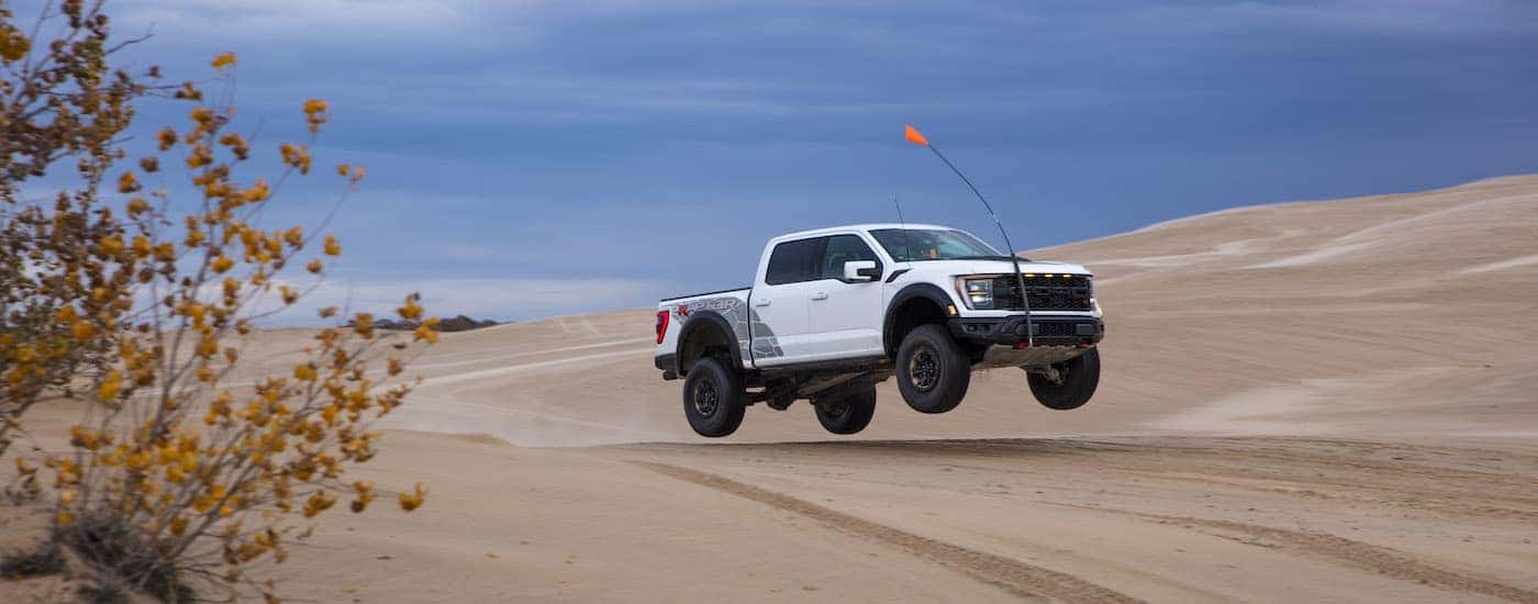 A white 2024 Ford F-150 Raptor R is shown from the side.