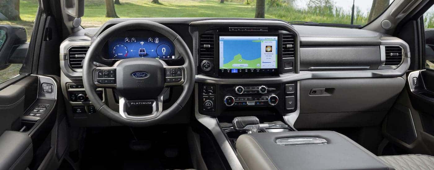 The black interior of a 2024 Ford F-150 is shown from the driver's seat.