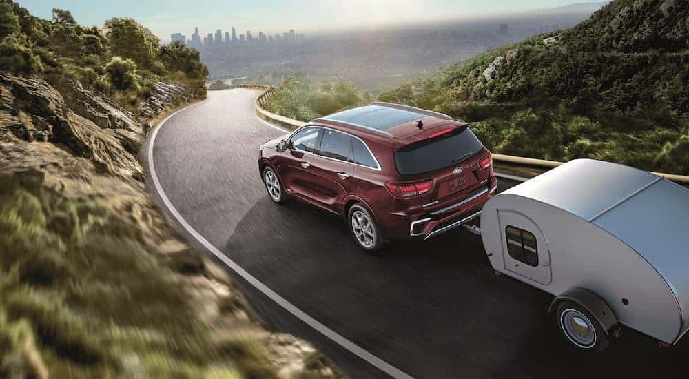 Rear view of a red 2020 Kia Sorento towing a trailer.