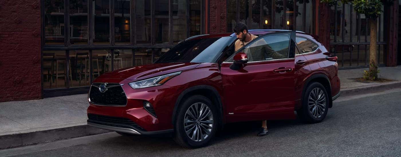 A red 2024 Toyota Highlander parked near a curb.