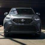 Front of a grey 2021 Toyota Highlander for sale in Dallas driving underneath a bridge.
