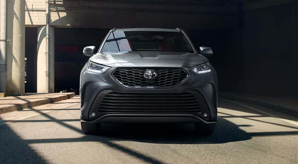 Front of a grey 2021 Toyota Highlander for sale in Dallas driving underneath a bridge.