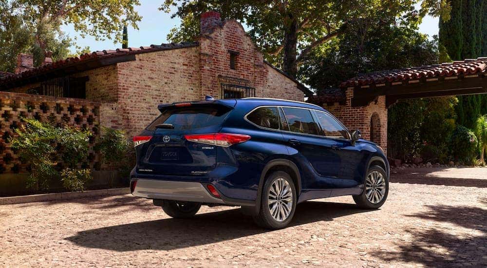 Rear of a blue 2023 Toyota Highlander Hybrid Platinum parked on a driveway.