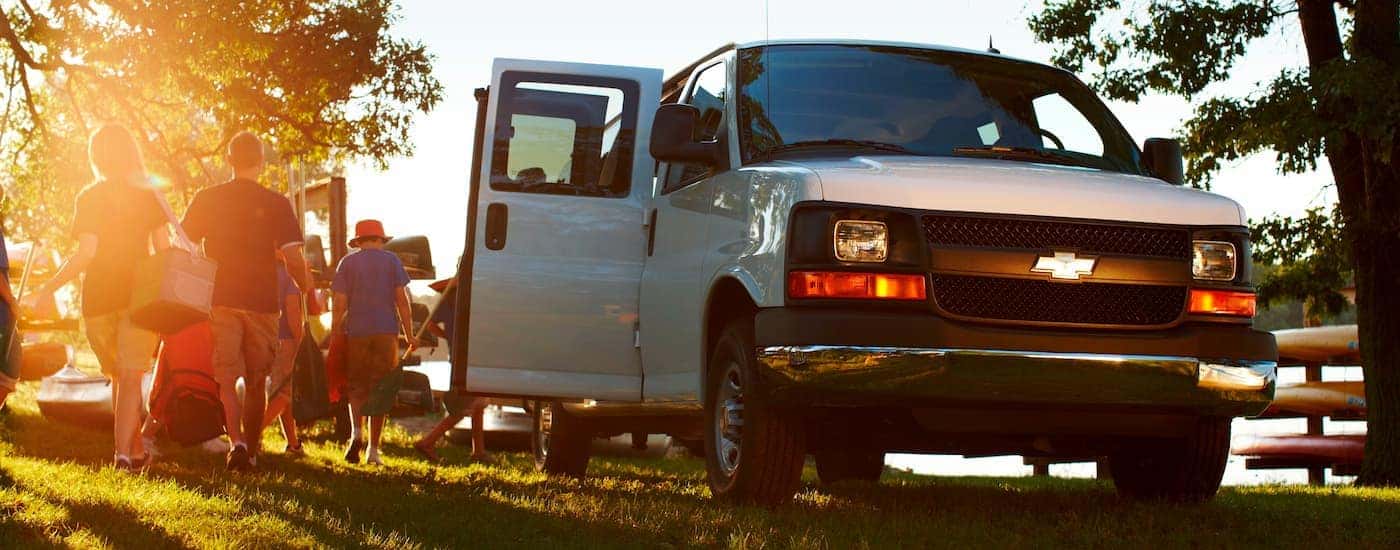 A white used 2016 Chevy Express 2500 for sale parked on a grassy hill.