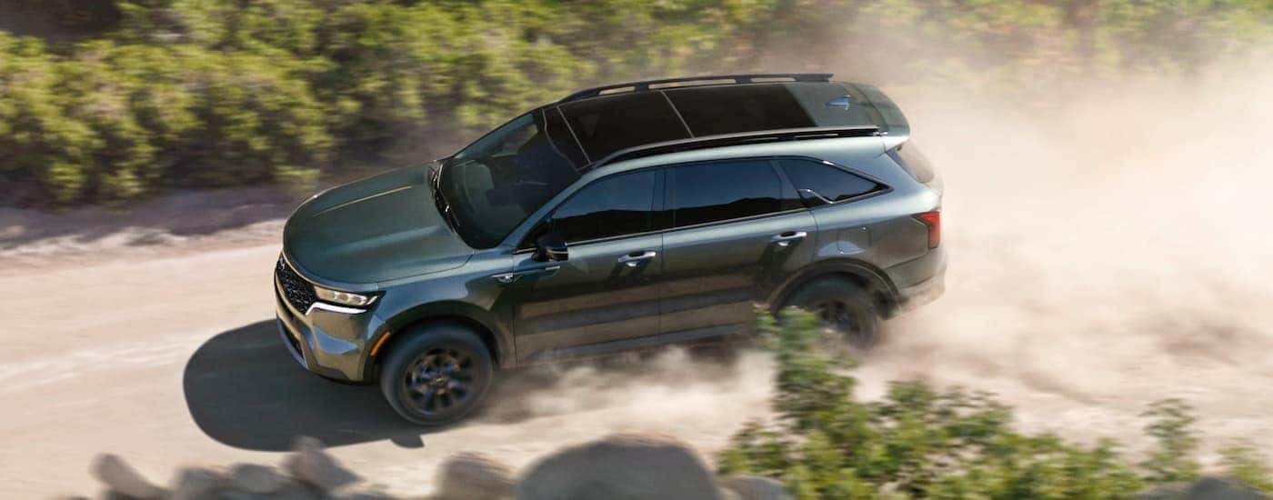High angle view of a grey 2022 Kia Sorento X-Line driving down a dirt road.