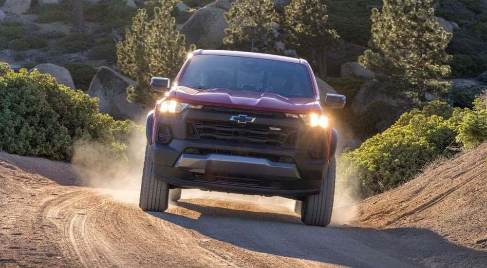 A red 2023 Chevy Colorado off-roading on a dirt trail