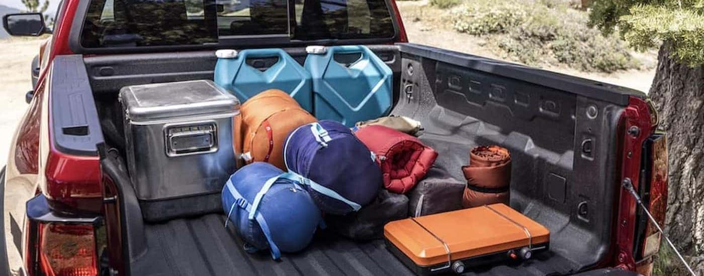 Camping gear in the bed of a red 2023 Chevy Colorado.