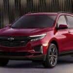 A red 2024 Chevy Equinox RS parked in a showroom.