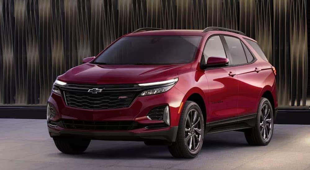 A red 2024 Chevy Equinox RS parked in a showroom.