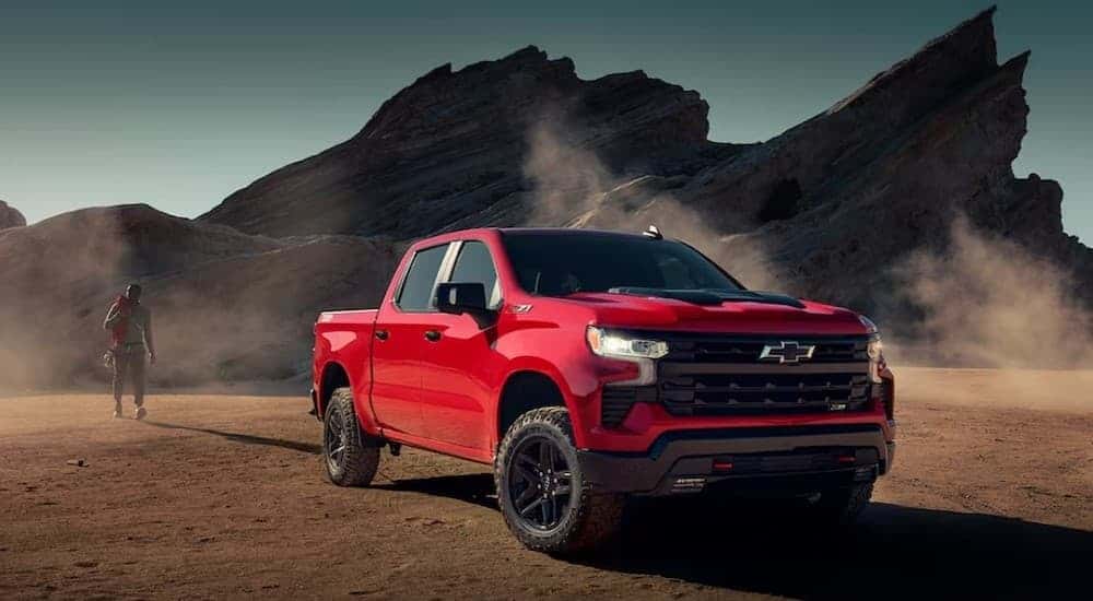 A red 2024 Chevy Silverado 1500 Trail Boss parked off-road.