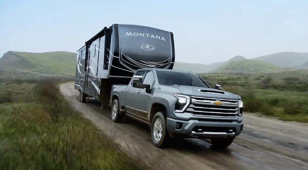 A gray 2025 Chevy Silverado 2500 HIgh Country towing a trailer.