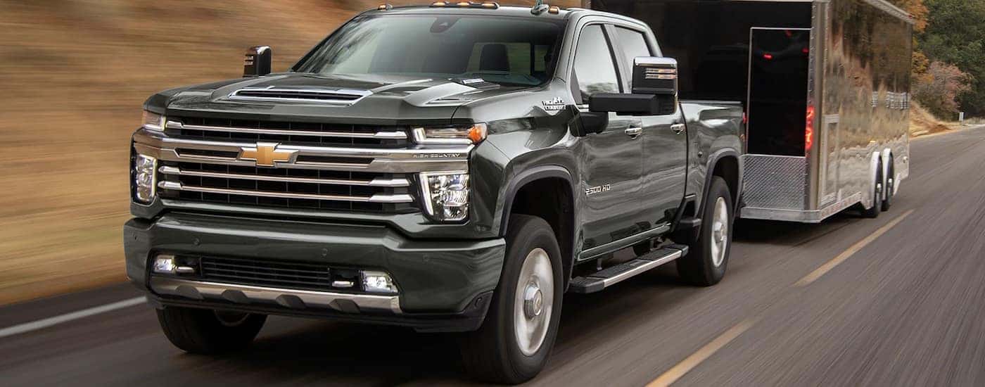 Black 2023 Chevy Silverado 2500HD High Country towing a trailer.
