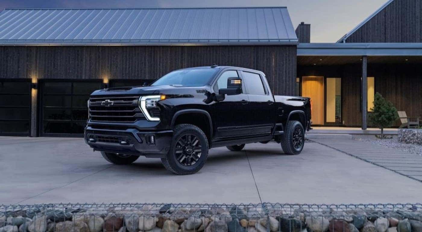A black 2024 Chevy Silverado 2500 High Country parked on a driveway.