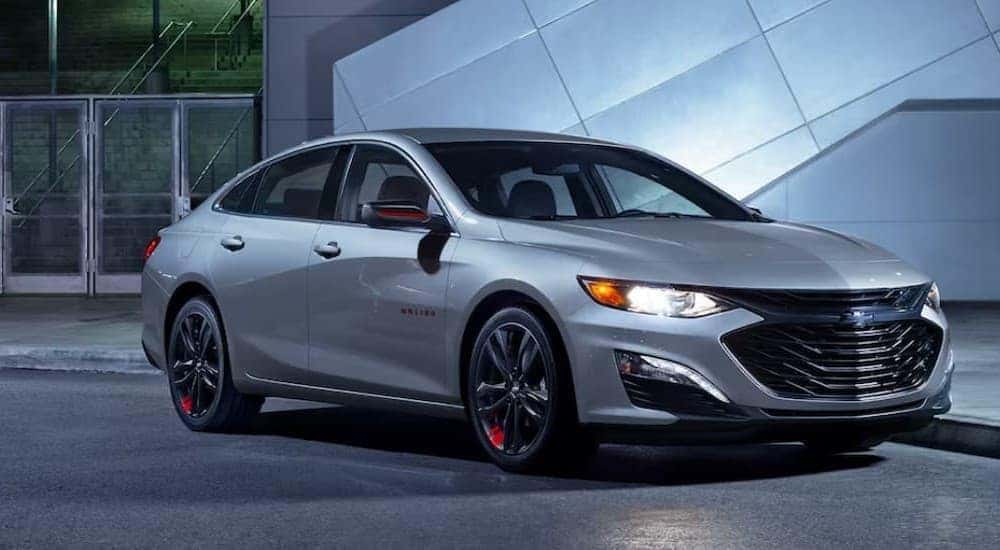 A silver 2024 Chevy Malibu 1LT parked in a city.