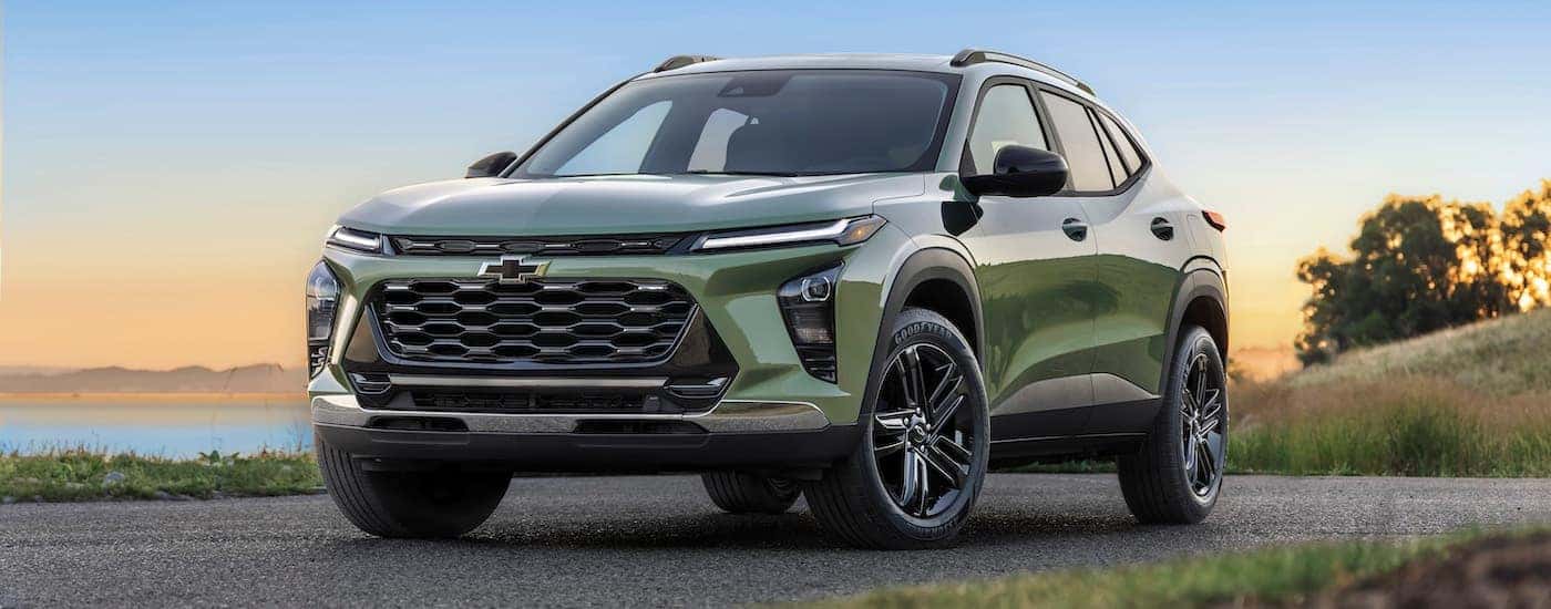 A green 2024 Chevy Trax ACTIV for sale parked near a lake.