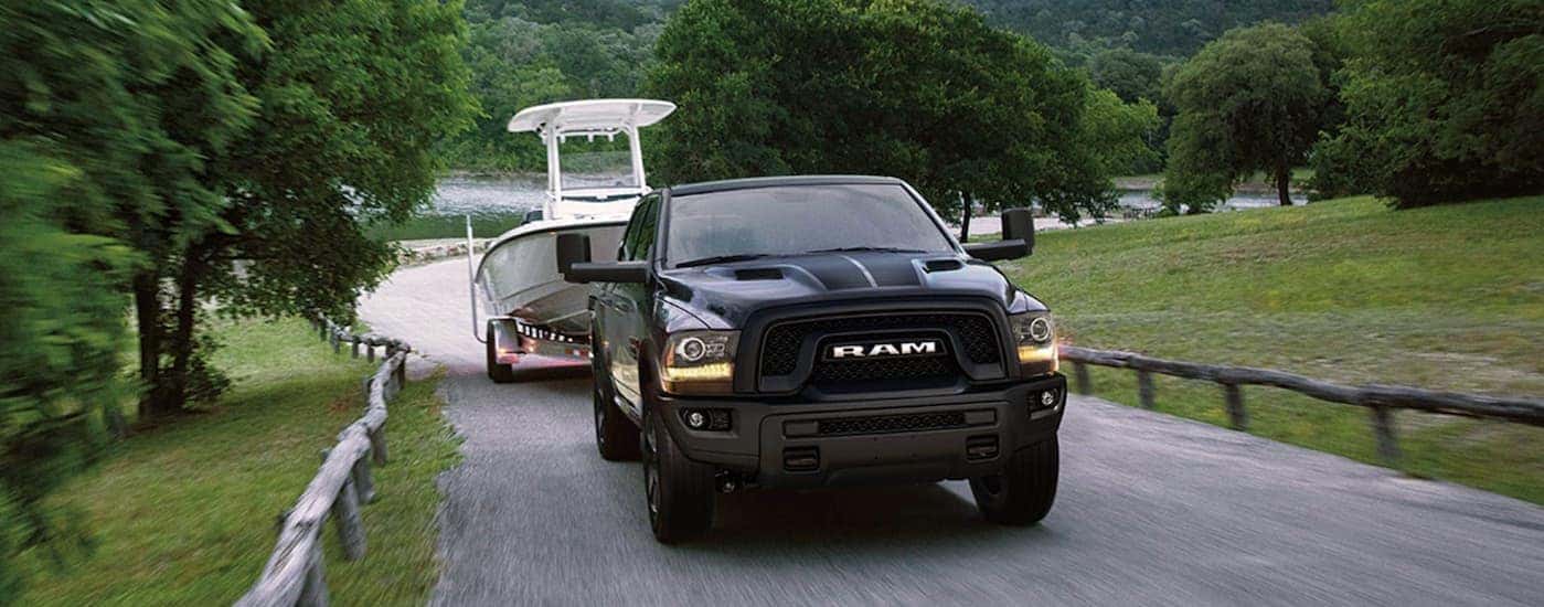 Black 2019 Ram 1500 for sale towing a boat.