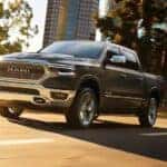 A dark gray 2019 Ram 1500 driving in a city
