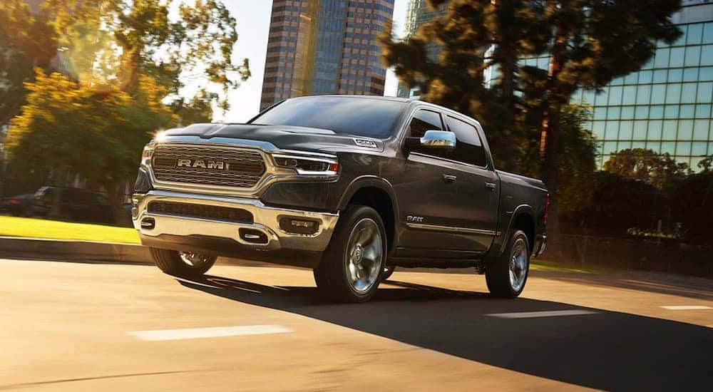 A dark gray 2019 Ram 1500 driving in a city