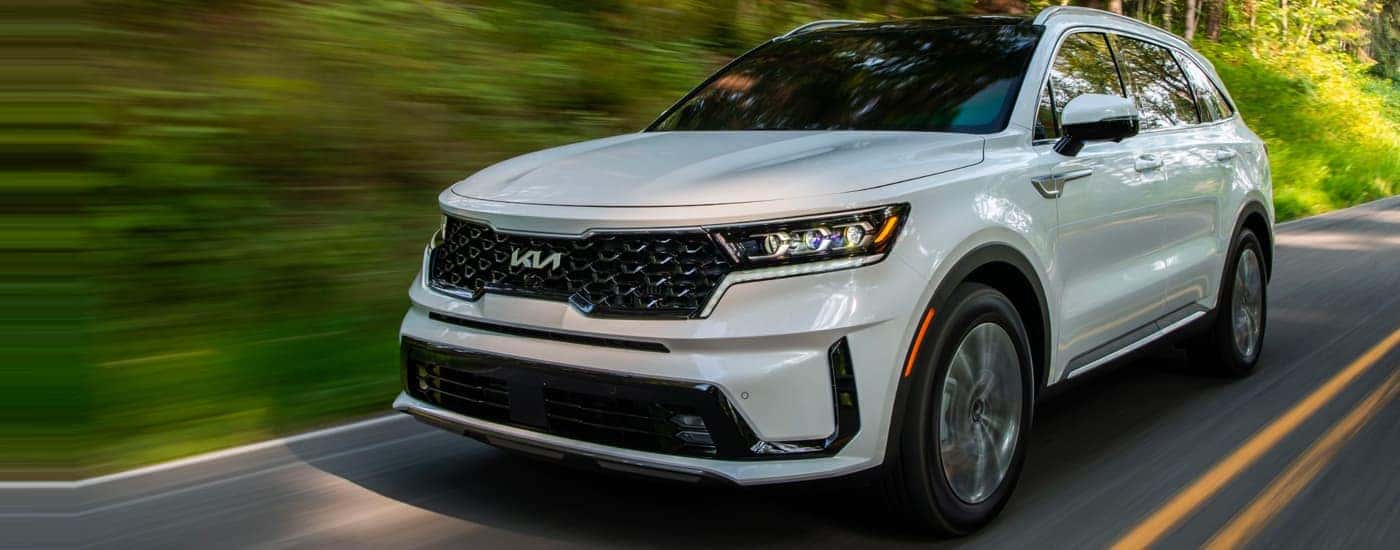 A white 2022 Kia Sorento for sale driving on a highway.
