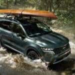 Green 2022 Kia Sorento driving through a river