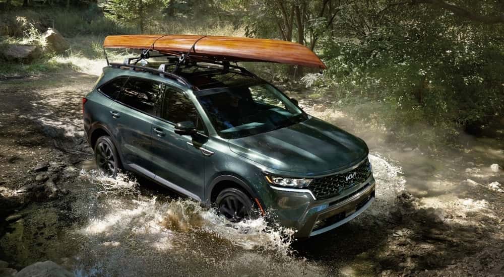 Green 2022 Kia Sorento driving through a river