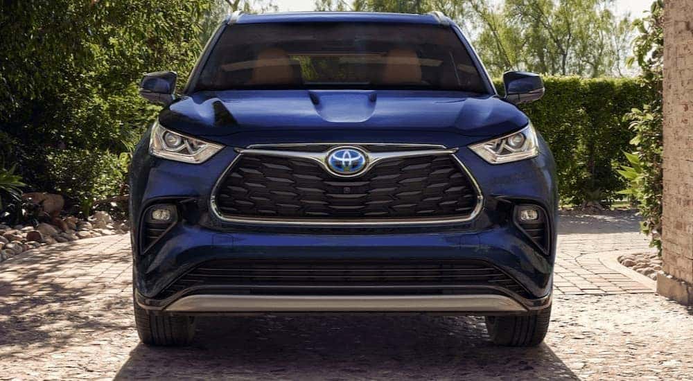A blue 2022 Toyota Highlander Hybrid Platinum parked in a driveway