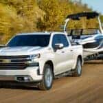 White 2021 Chevy Silverado 1500 for sale in Louisville towing a boat.