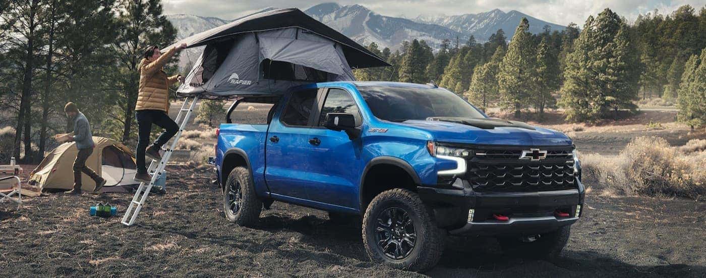 A blue 2025 Chevy Silverado ZR2 parked at a campsite.