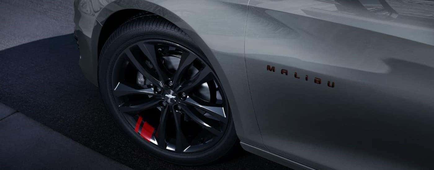 Black rim and tire on a gray 2023 Chevy Malibu Redline for sale