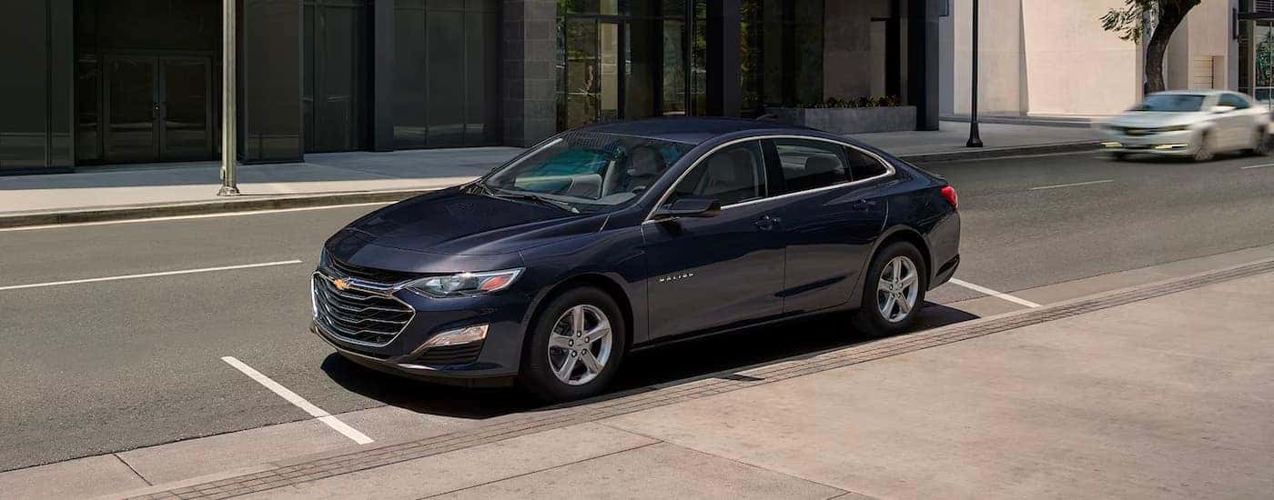 A blue 2023 Chevy Malibu parked in a city