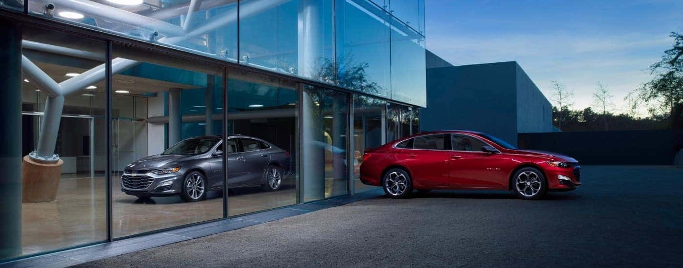 A grey and a red 2019 Chevy Malibu at a dealership.