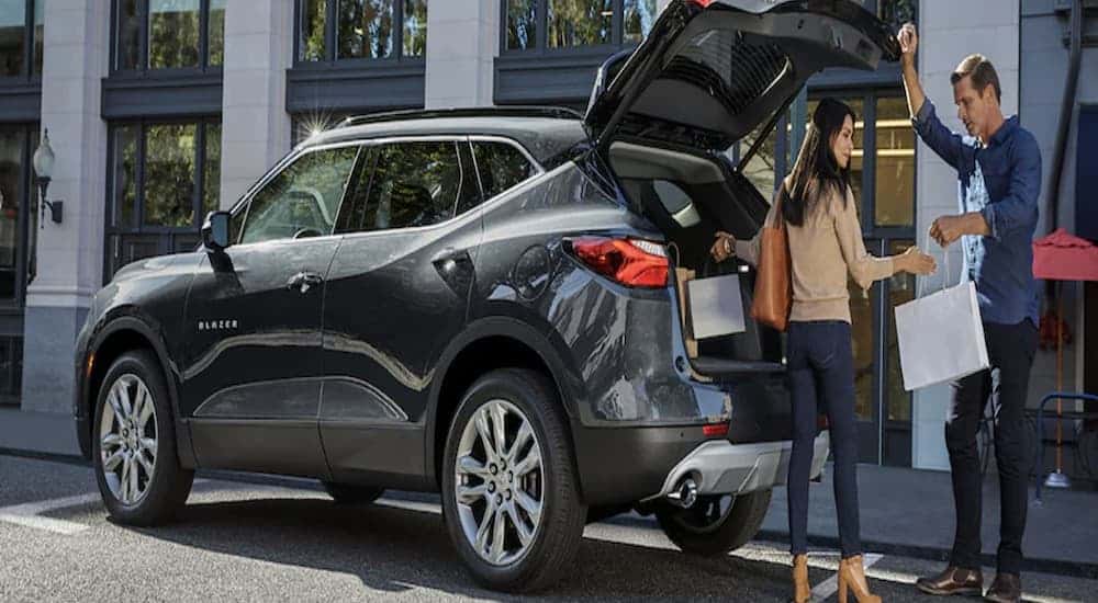 Two people stand by the trunk of a 2022 Chevy Blazer for sale.