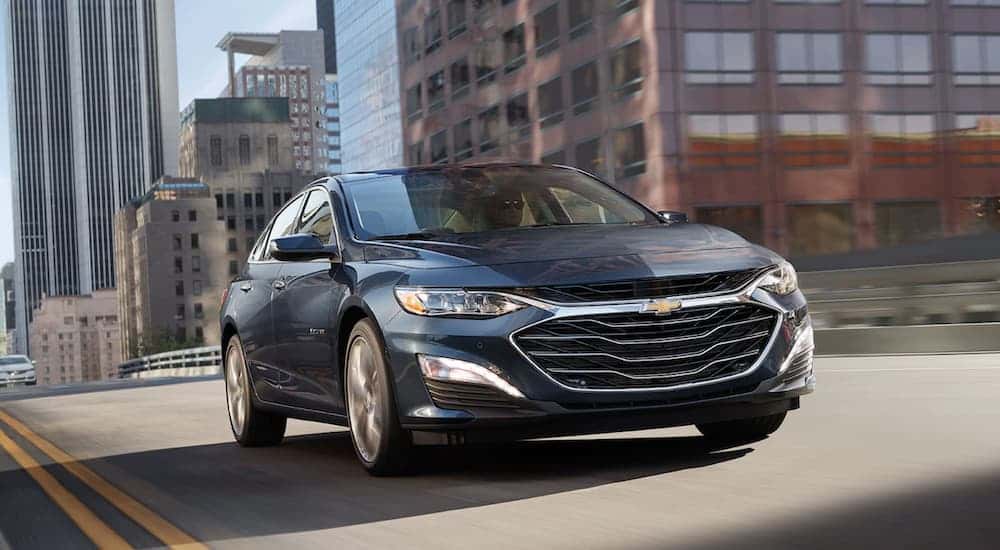 Blue 2022 Chevy Malibu from the front at an angle driving down the road.