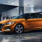 Orange 2021 Nissan Sentra for sale parked at an angle in front of a building.