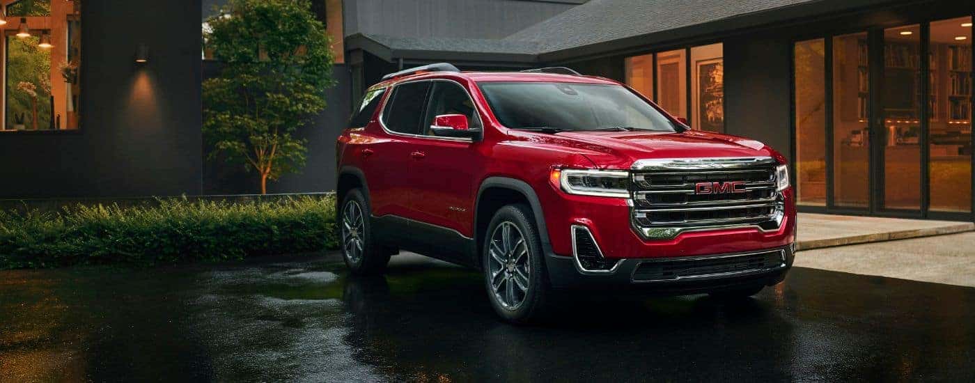A red 2023 GMC Acadia parked in a driveway