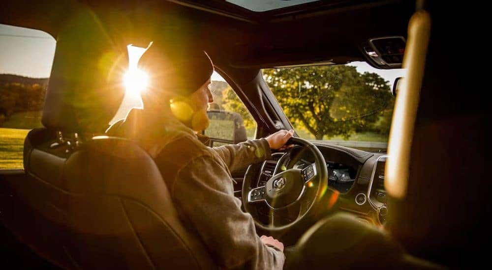 A person sits in the driver seat of a 2023 Ram 2500 for sale