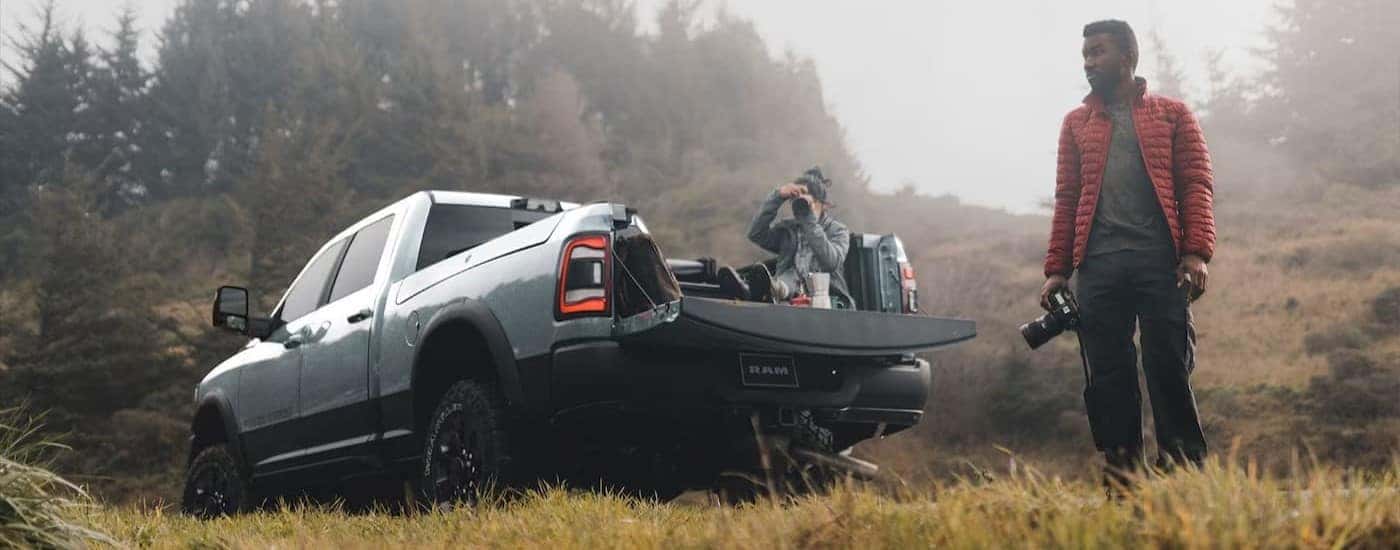 A person taking photos out of the bed of their silver 2024 Ram 2500